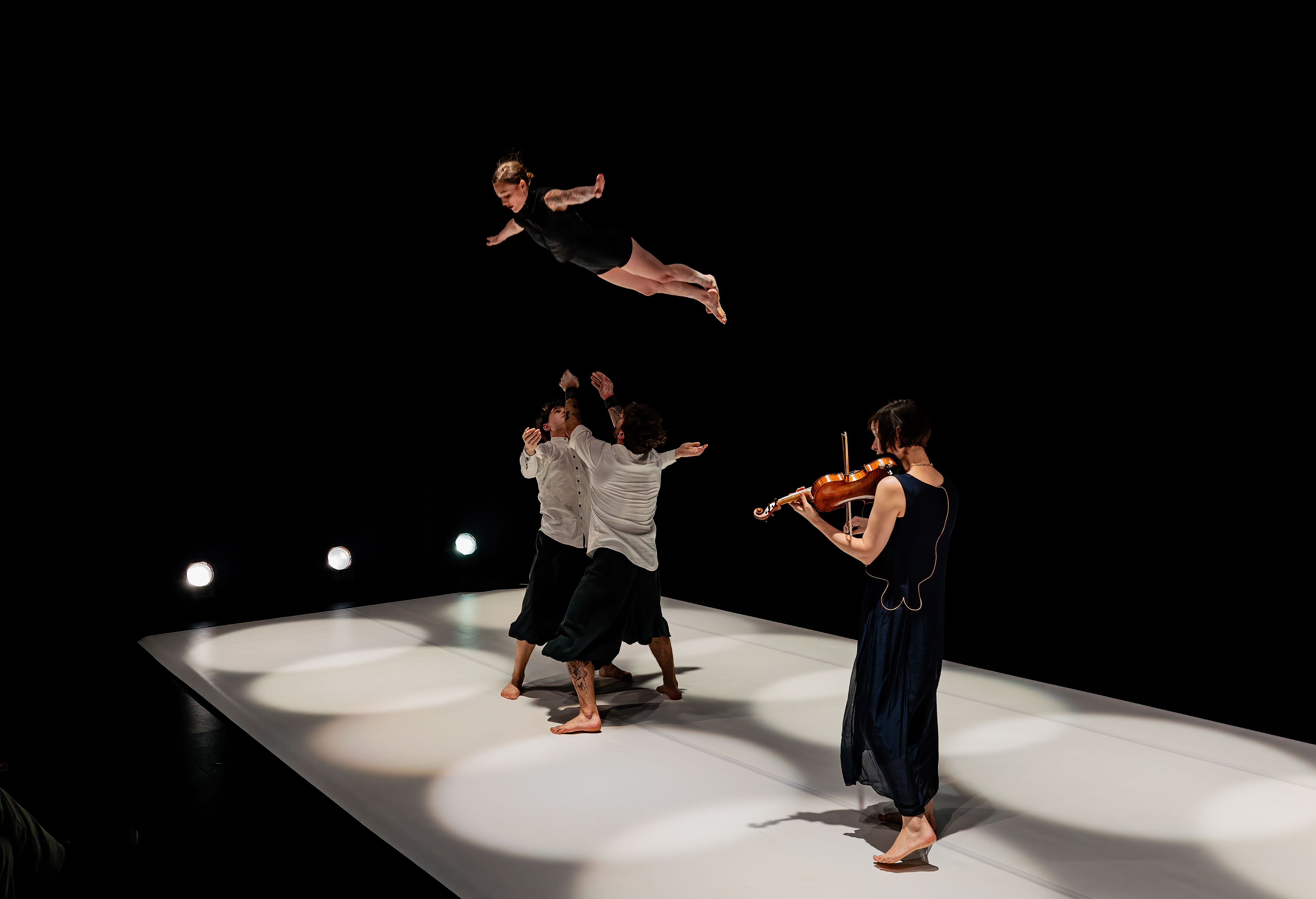 A theater house surrounded by green landscape with a rainbow above it